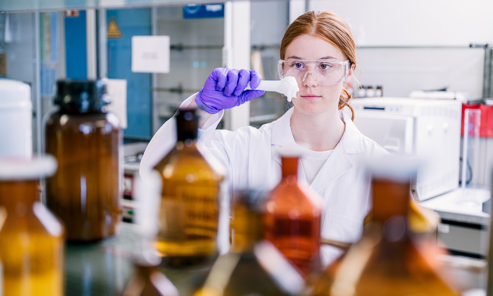 [Translate to Englisch:] Eine Chemie-Studentin untersucht im Labor eine selbst hergestellte Salbe