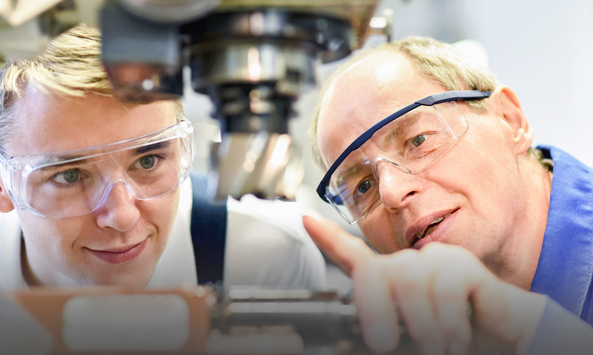 [Translate to Englisch:] Ein Lehrer erklärt einem Schüler ein technisches Gerät